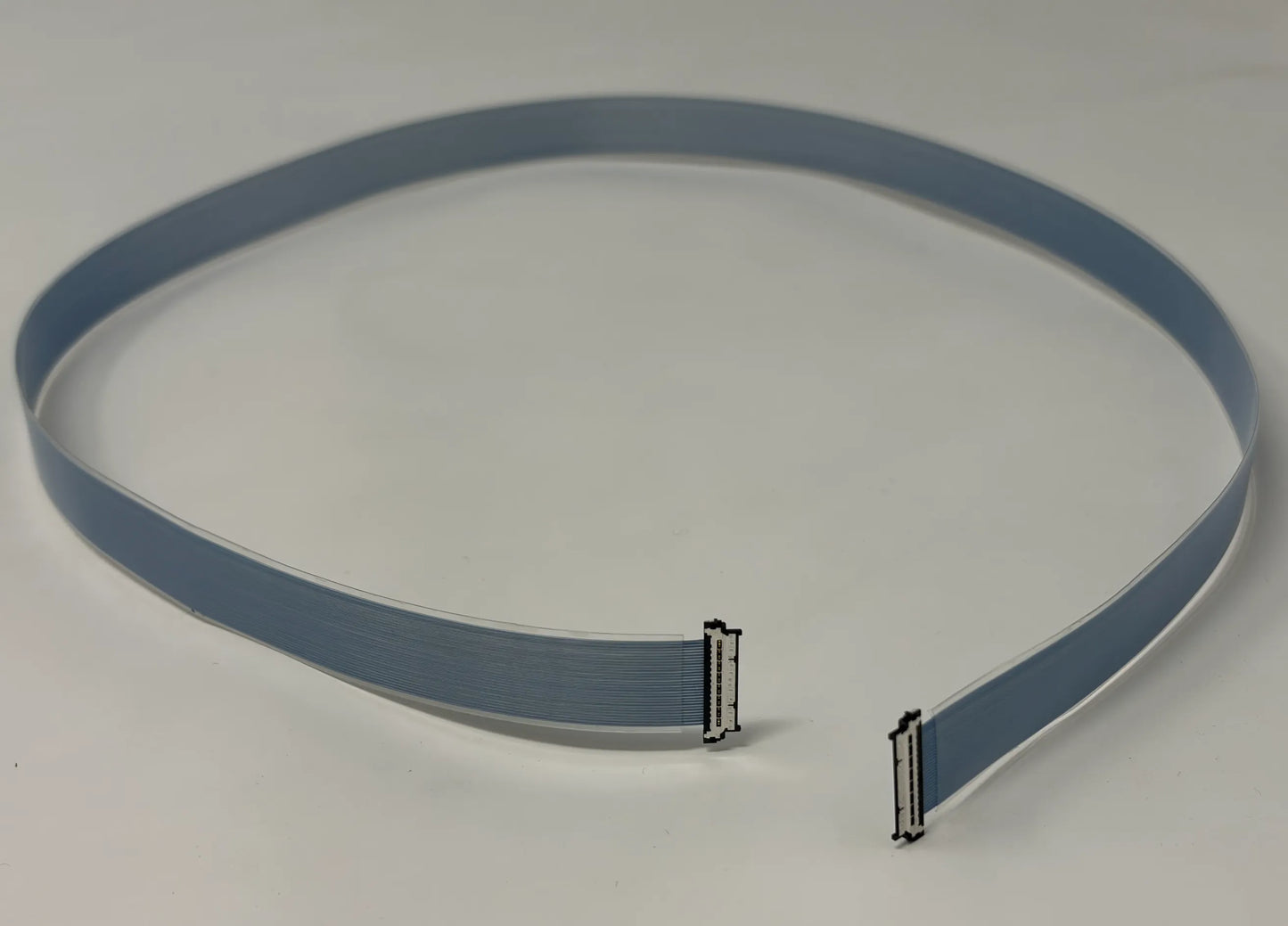 Gray flat micro coaxial cable with connectors on a white background