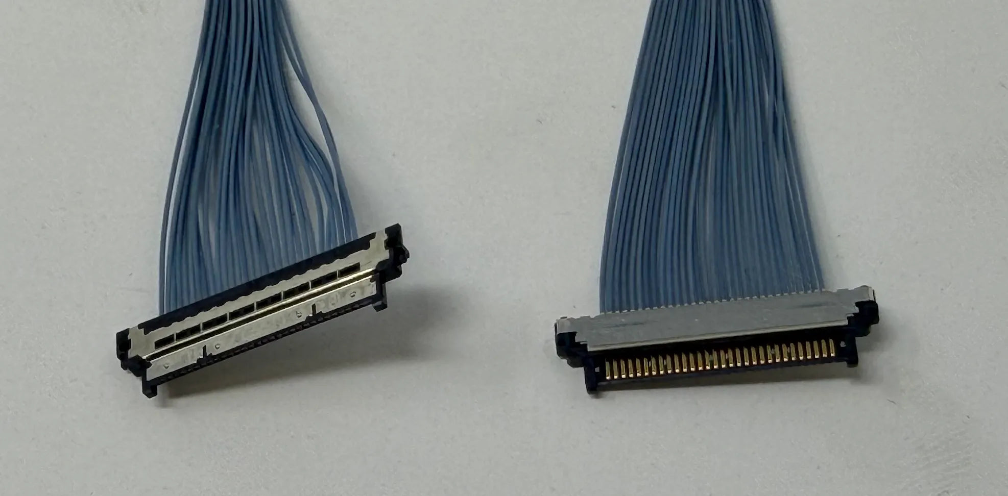 Two micro coaxial cable connectors on a white background